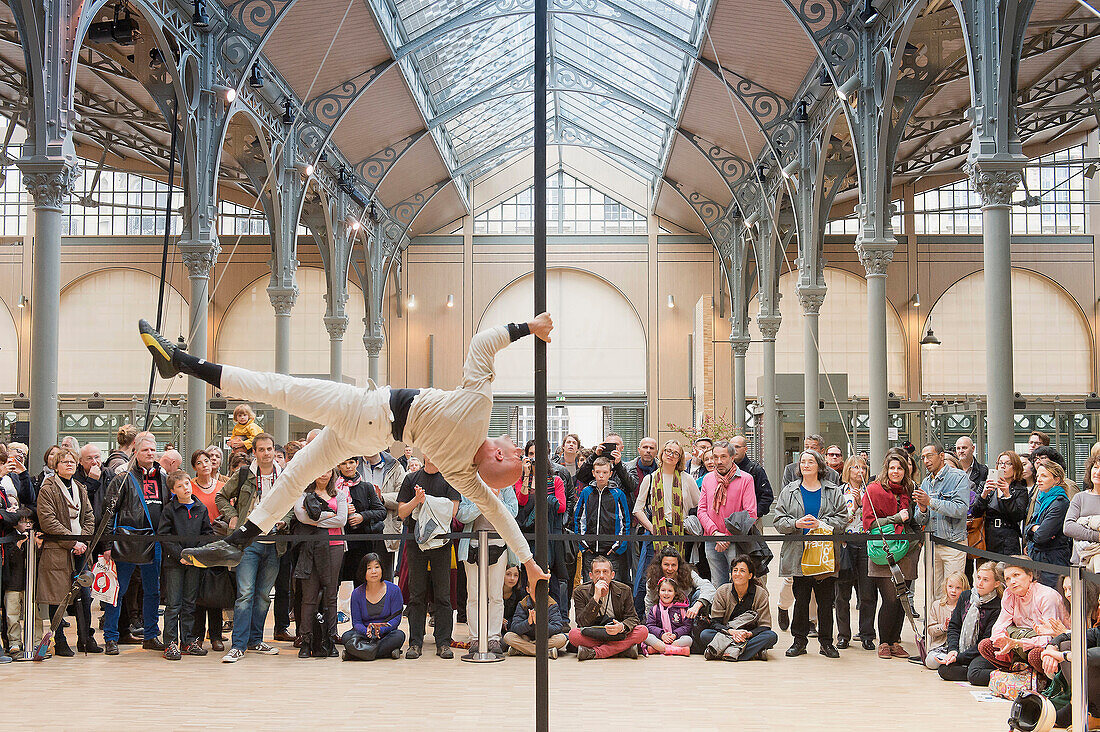 Europe, France, Paris (75), 3rd arrondissement, Le Marais, the 'Carreau du Temple'. April 25th, 2014. Opening day. Acrobatic show on a Chinese Pole by Rafael de Paula. It is a former clothes market that was redeployed in a cultural and sport center in 201