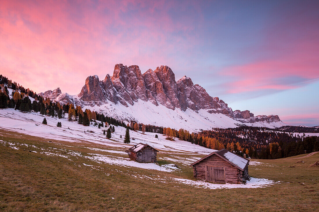 Sunrise with two wooden lodges and Odle Dolomites, Malga Gampen, Funes, Bolzano, Trentino Alto Adige - Sudtirol, Italy, Europe
