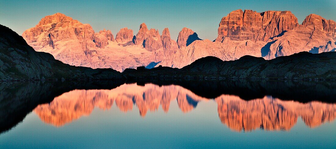 Nero lake, Adamello Brenta natural park, Trentino Alto Adige, Italy, Panoramic photo of the Brenta dolomites that are reflected into the lake at sunset