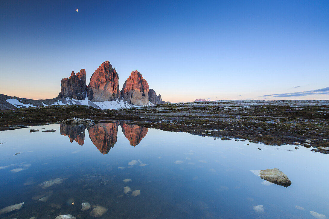 Dawn illuminates the Three Peaks of Lavaredo reflected in the lake, Sesto Dolomites Trentino Alto Adige Italy Europe