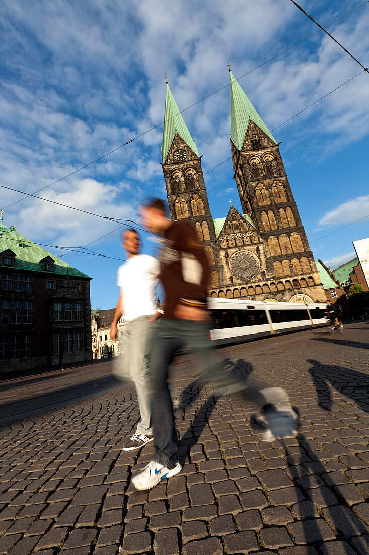 Männer gehen am Marktplatz am St. Petti Dom, Bremen, Deutschland