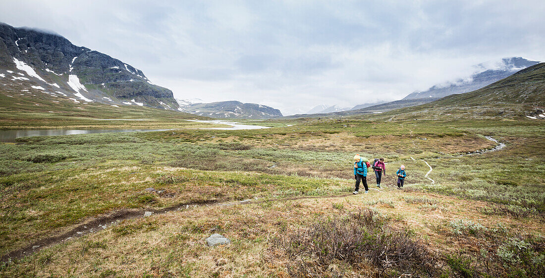 Zwei Mädchen und eine Frau wandern auf dem Kungsleden Trek. Von Saltoluokta Fjällstation zur Sitojaurestugorna (-hütte), 20 km. Laponia, Lappland, Schweden.