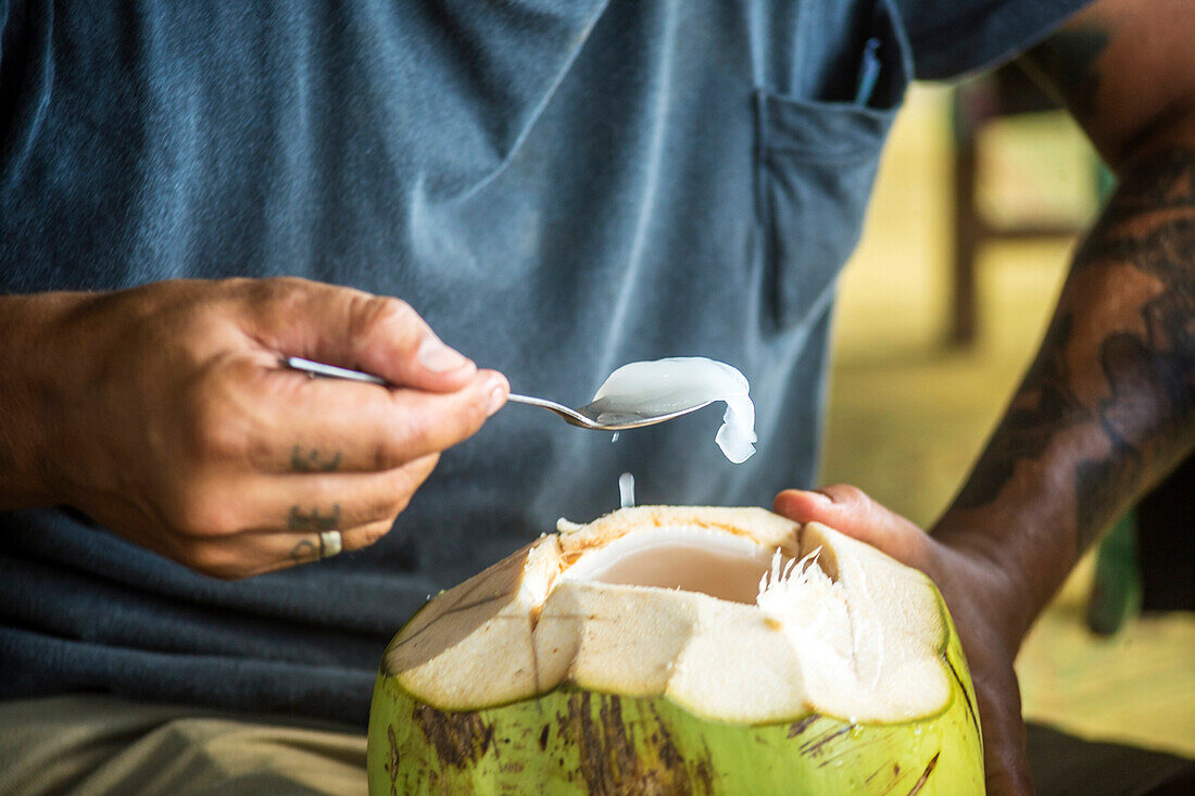 Man Eating Cooked Coconut With A Spoon