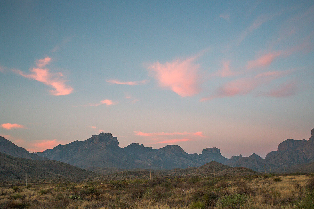 A Mountain Range In The Distance Under A Softly Glowing Dawn Sky