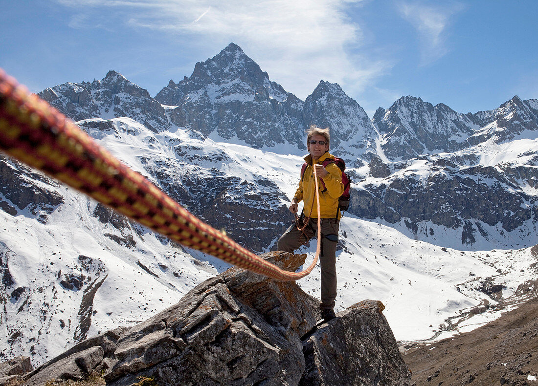 Mountaineer pulls rope tight to teammate, mountain ridge