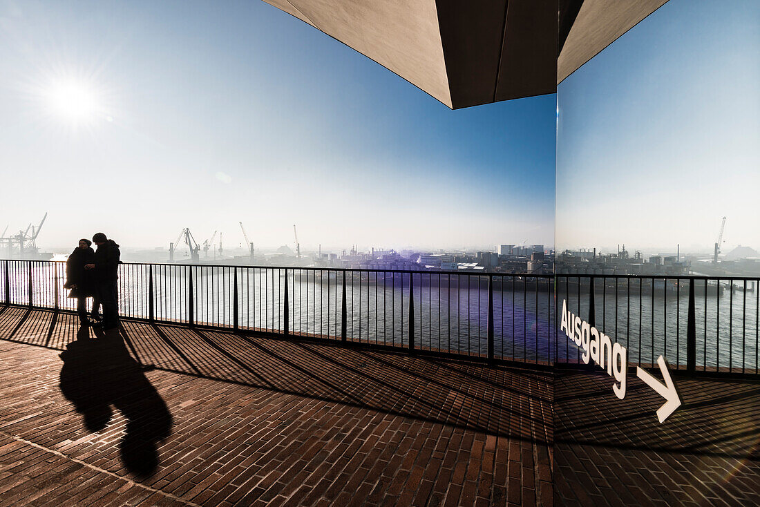 Ein Paar in der Morgenstimmung auf der Plaza der Elbphilharmonie mit Blick auf das Hafengebiet, Hamburg, Deutschland