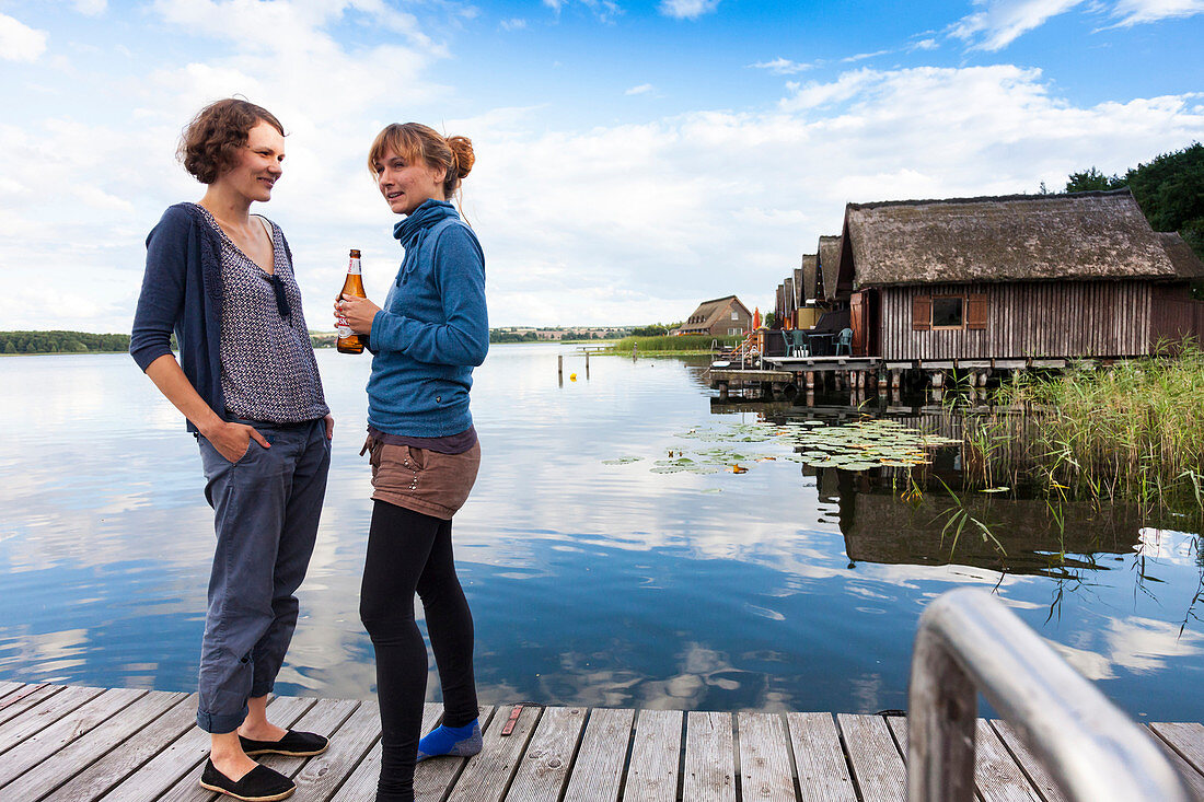 Frauen auf einem Bootssteg, Holzsteg, am Inselsee, Partygäste, Frau, Bootshäuser, Mecklenburgische Schweiz, Mecklenburgische Seen, Mecklenburgisches Seenland, Güstrow, Mecklenburg-Vorpommern, Deutschland, Europa