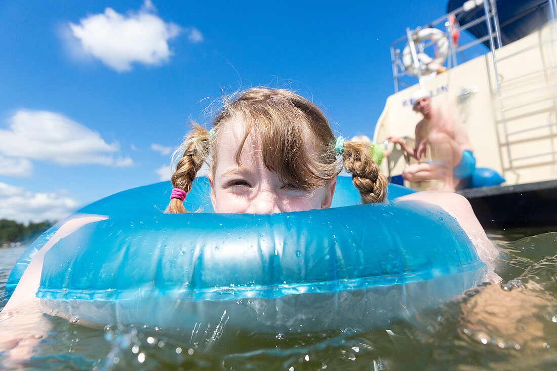 Little girl in a swimming ring, Swimming fun with a family, houseboat tour, south of lake Müritz, lake, Zotzensee, Kuhnle-Tours, Mecklenburg lakes, Mecklenburg lake district, MR, Mecklenburg-West Pomerania, Germany, Europe