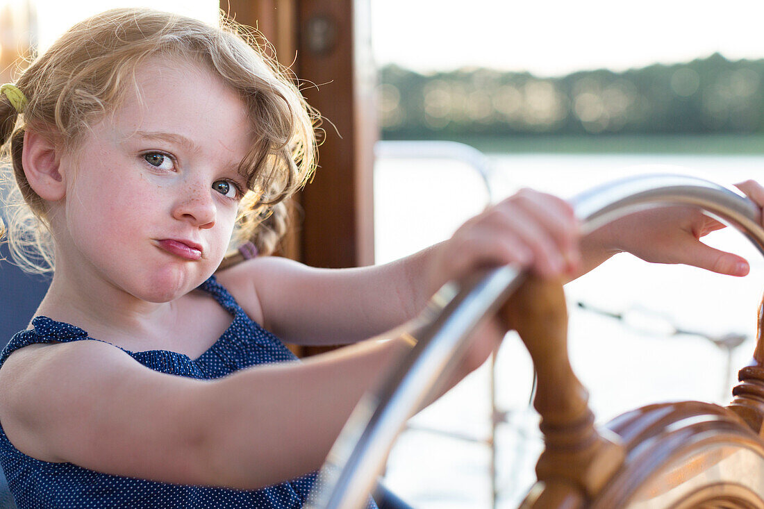 Young girl at the steering wheel, houseboat tour, Lake Mirower See, Kuhnle-Tours, Mecklenburg lakes, Mecklenburg lake district, MR, Mirow, Mecklenburg-West Pomerania, Germany, Europe