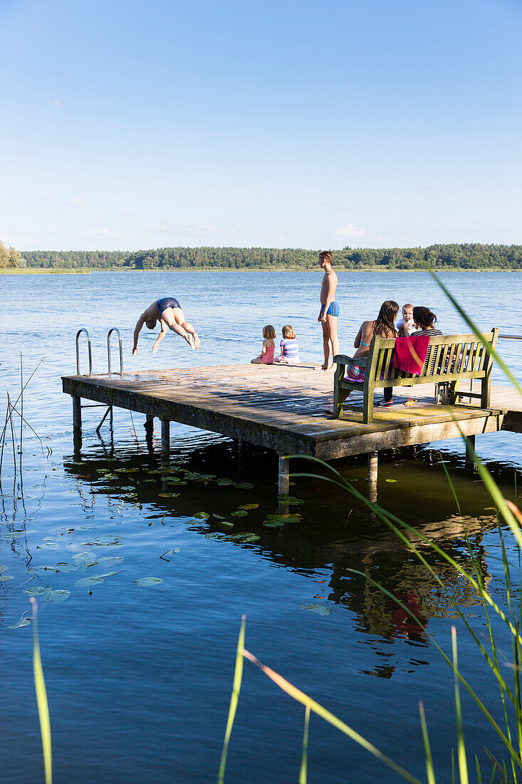 Badestelle am Seehotel Neuklostersee, Baden im See, Sprung ins Wasser, Familie auf Steg, Sommer, Urlaub, Mecklenburgische Seenplatte, Mecklenburgische Seen, Neukloster, Mecklenburg-Vorpommern, Deutschland, Europa