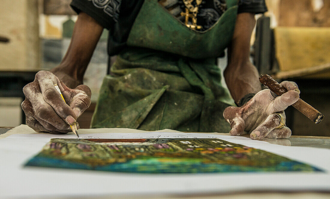 'Close up of the paint-covered hands of a Cuban painter signing his work and holding a cigar in El Taller Experimental de Gr?ífica (Experimental Graphic Studio''), a cooperative graphic print shop and art studio in Old Havana or Habana Vieja, La Habana, C