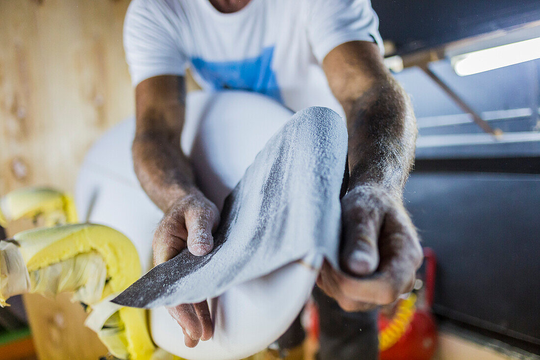 Surfboard Shaper Shaping A Board With Sand Paper
