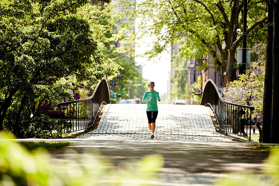 A Woman Running On Bridge Along The Charles River In Boston