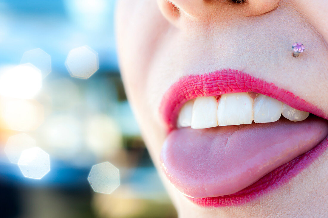 Nahaufnahme des Mundes einer Frau mit Zunge, Zähnen und Piercing