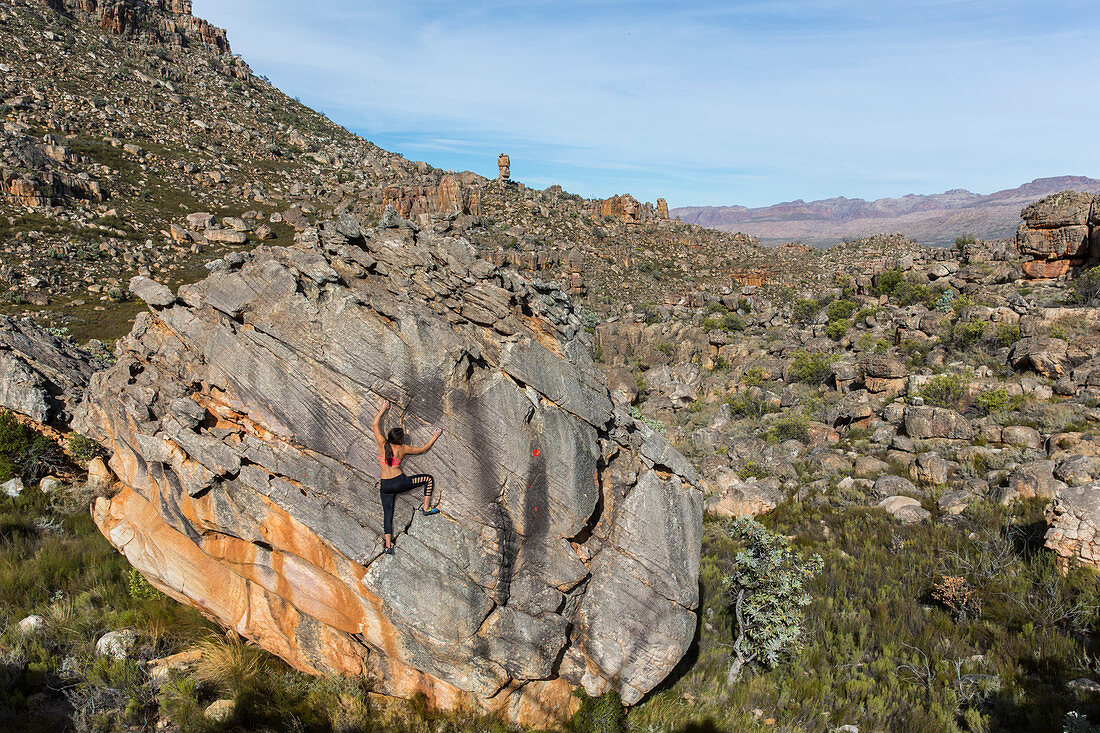 A female climber climbing on a boulder in the Cederberg Mountains