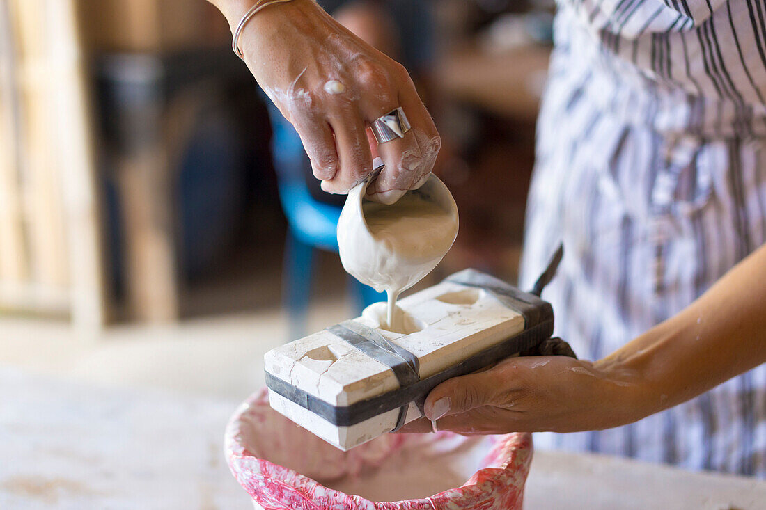 Young Woman Pouring Clay In Mold At Ceramic Workshop