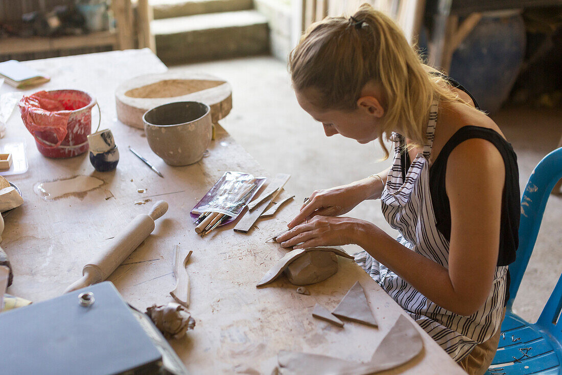 Woman Hand Using Craft Knife On Clay In Ceramic Workshop