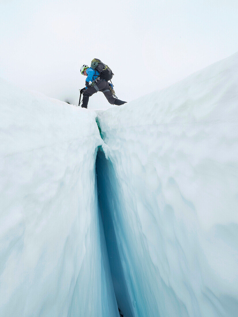 Climber Steps Over A Crevasse On The Coleman Glacier On Mount Baker