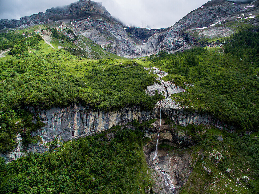 Alpine Landscape With A Waterfall Tumbling Over A Rocky Ledge In Canton Bern, Switzerland