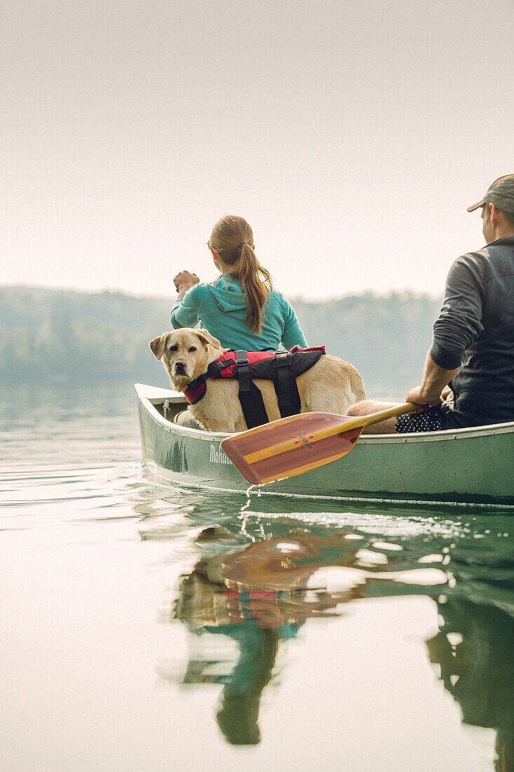 Man And Woman With Their Dog Canoeing On Caspian Lake