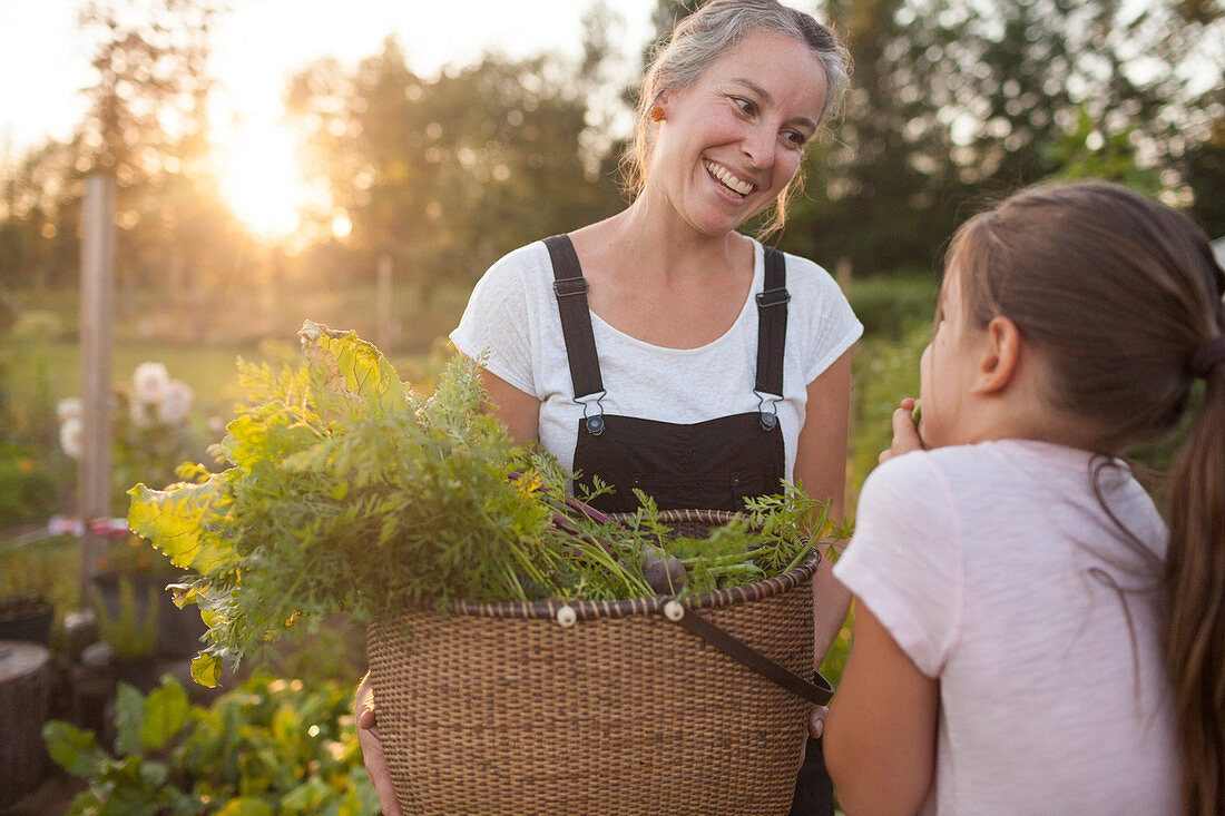A Mother And Daughter Share A Fun Moment While Harvesting Vegetables