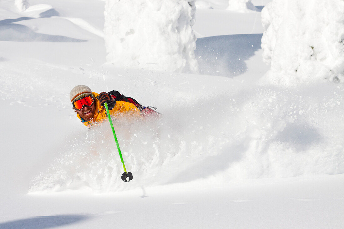 Male Skier Makes A Deep Powder Turn In Snowy Landscape At Whitefish, Montana, Usa