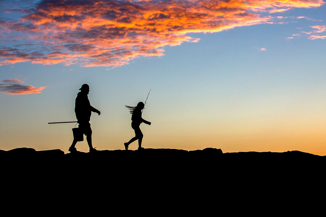 Silhouette Of Father And Daughter Head Out On A Jetty To Go Fishing