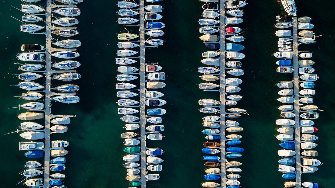 Aerial View Of Nyon Harbor With Four Parallel Jetties To Which A Number Of Recreational Boats Are Docked