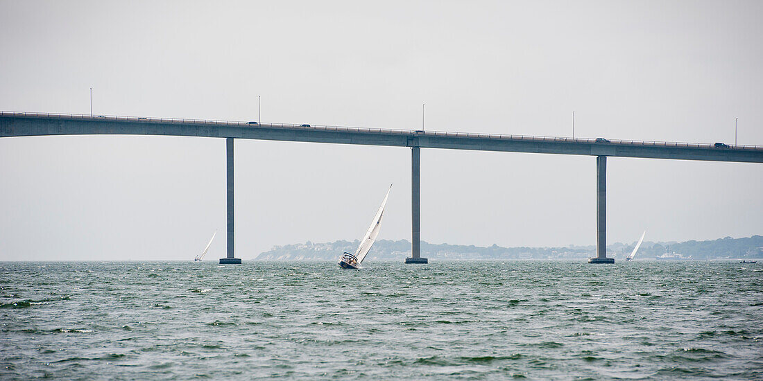 A boat sailing under a bridge on Narragansett Bay, Rhode Island