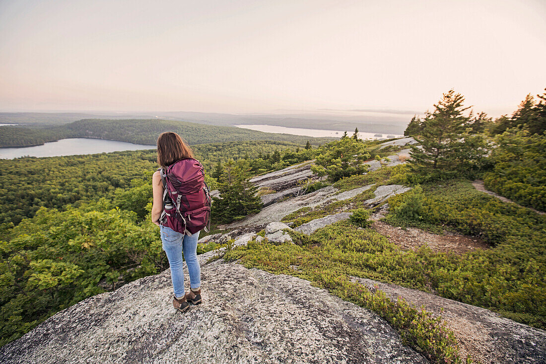 A Female Hiker Looking Over The View From Great Pond Mountain, Maine Coast