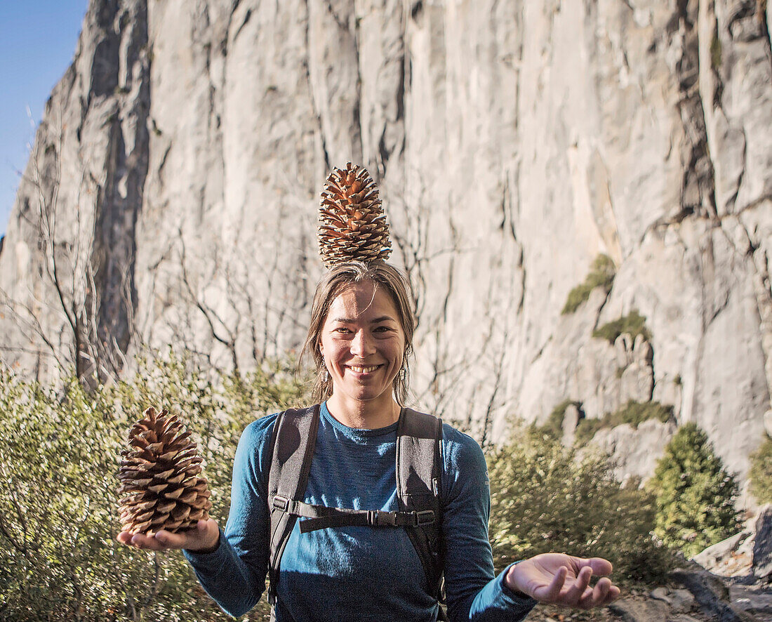A Young Woman Playing With Pinecones While Hiking In Yosemite National Park, California