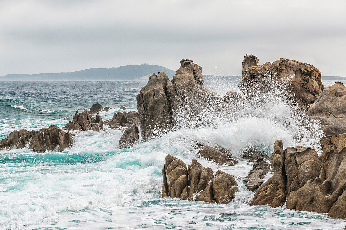 Italien, Sardinien, Das Meer von Villasimius im Sommer mit Wellen, die auf den Felsen krachen