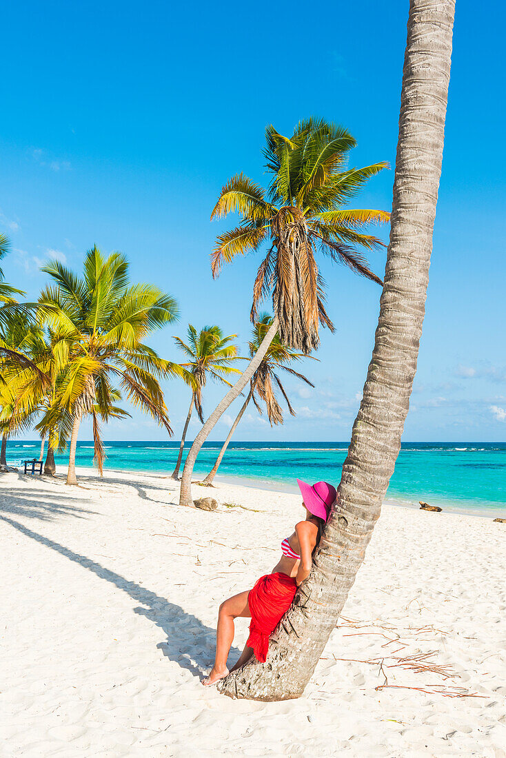 Canto de la Playa, Saona Island, East National Park , Parque Nacional del Este , Dominican Republic, Caribbean Sea,  Beautiful woman with red sarong relaxing on the palm-fringed beach , MR