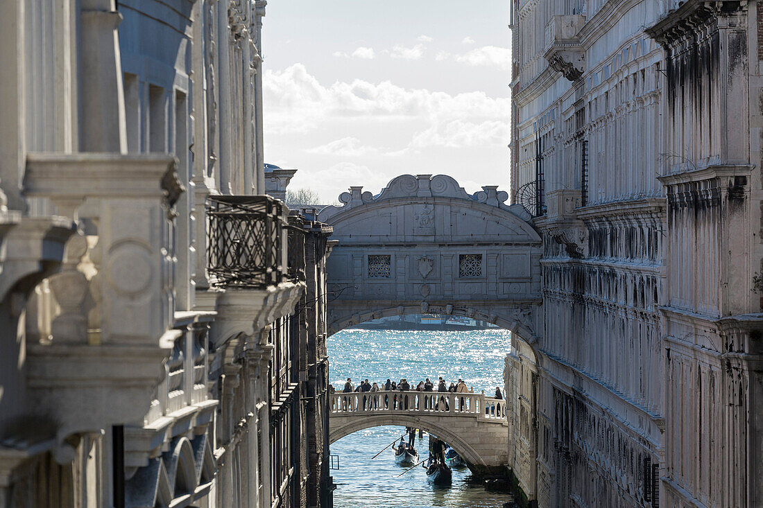 Blick auf Seufzerbrücke aus weißem Kalkstein umgeben von historischen Gebäuden und typischen Gondeln im Hintergrund Venedig Venetien Italien Europa