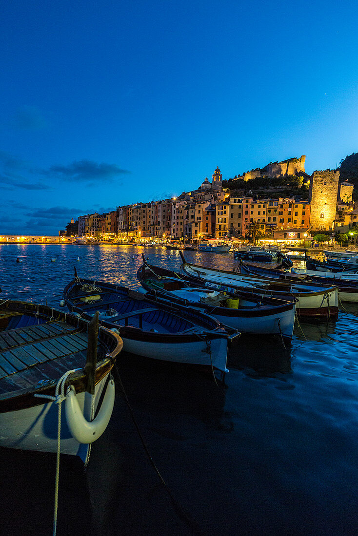 View of blue sea and boats surrounding the colorful village at dusk Portovenere province of La Spezia Liguria Italy Europe