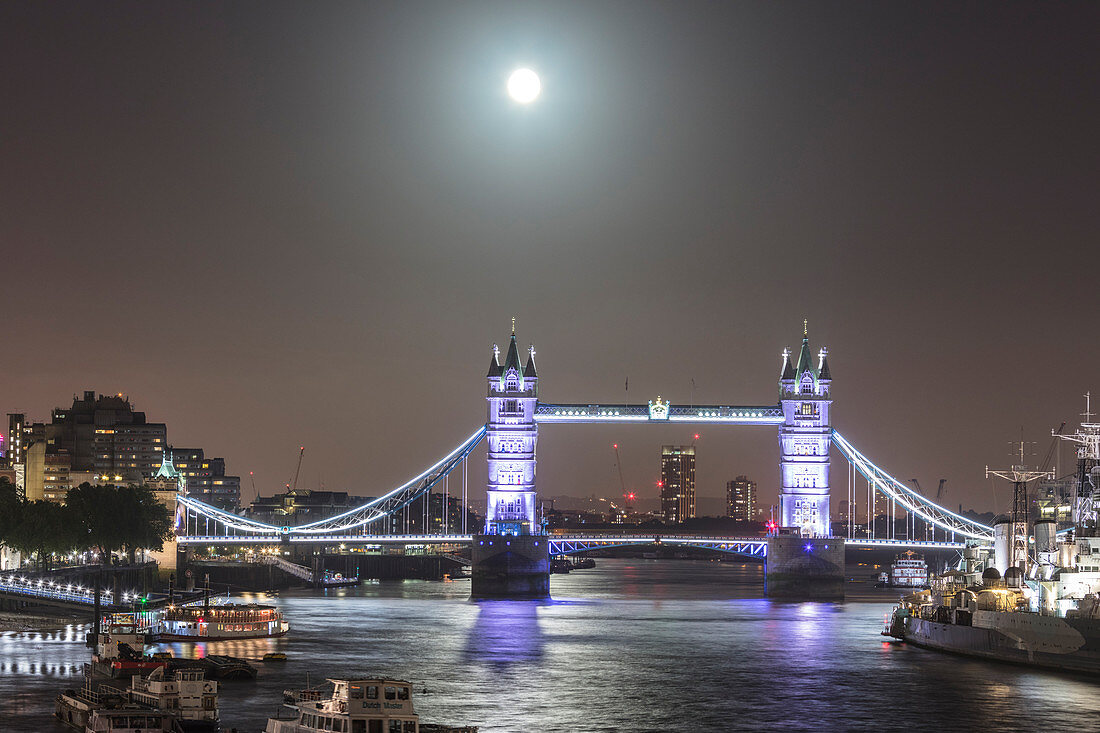 Full moon on the illuminated Tower Bridge reflected in river Thames London United Kingdom
