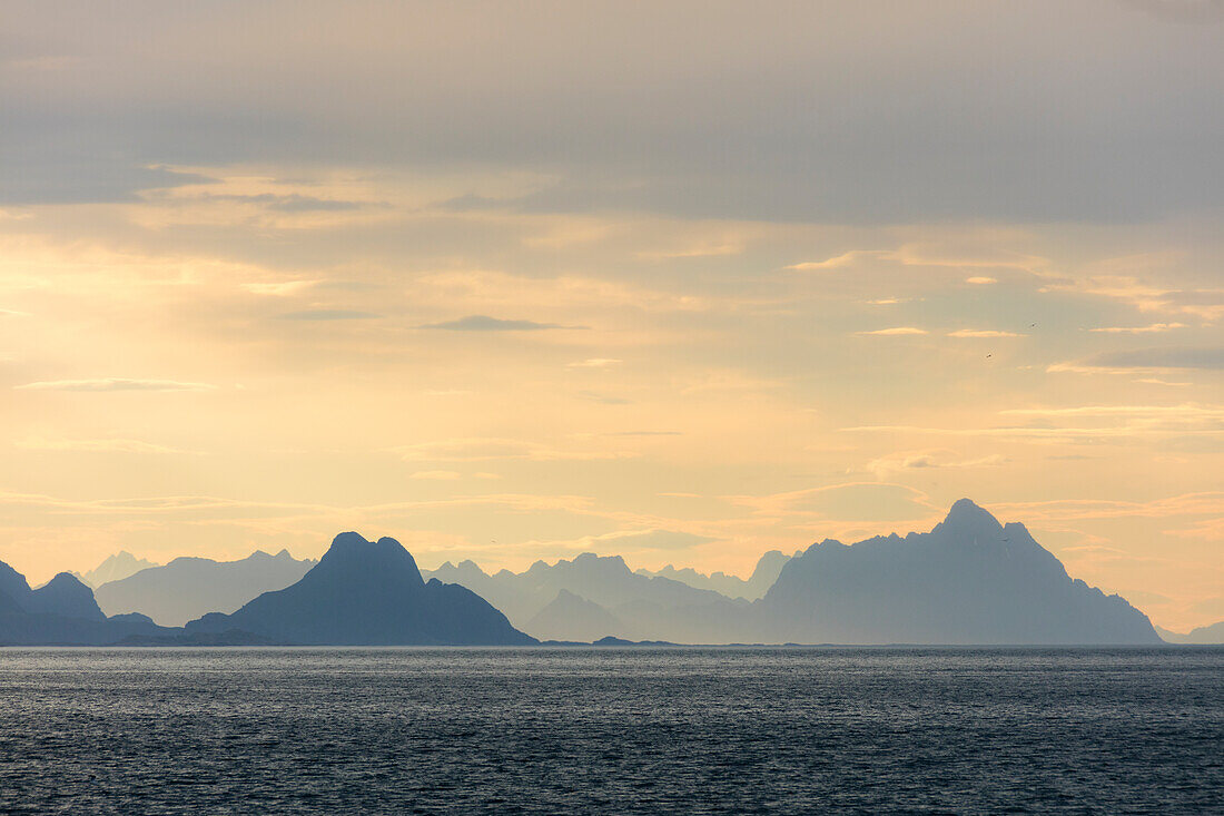 Mitternachtssonne leuchtet die felsigen Gipfel mit Blick auf das klare Meer Lofoten Inseln Norwegen Europa