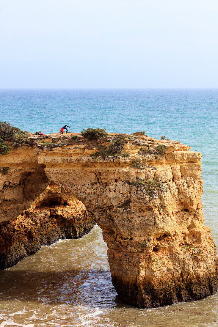 Woman practises gymnastics on the rocky cliffs Albandeira Lagoa Municipality Algarve Portugal Europe