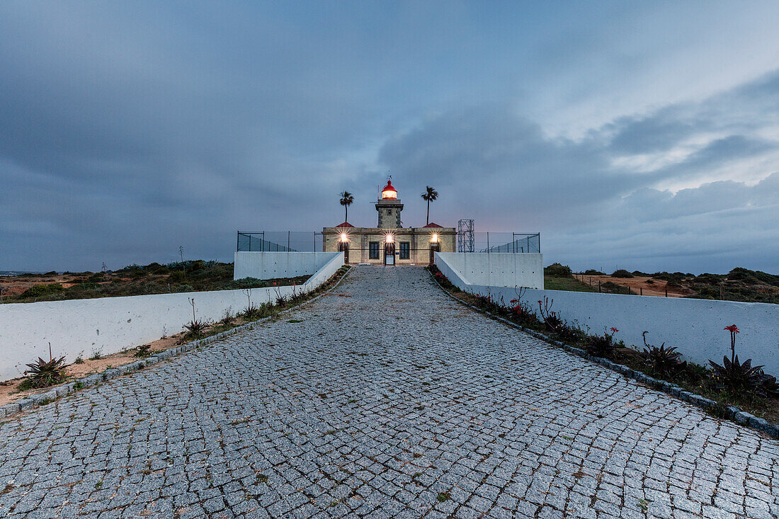 Dämmerung leuchtet der Leuchtturm, umgeben von dem Atlantischen Ozean Ponta Da Piedade Lagos Algarve Portugal Europa