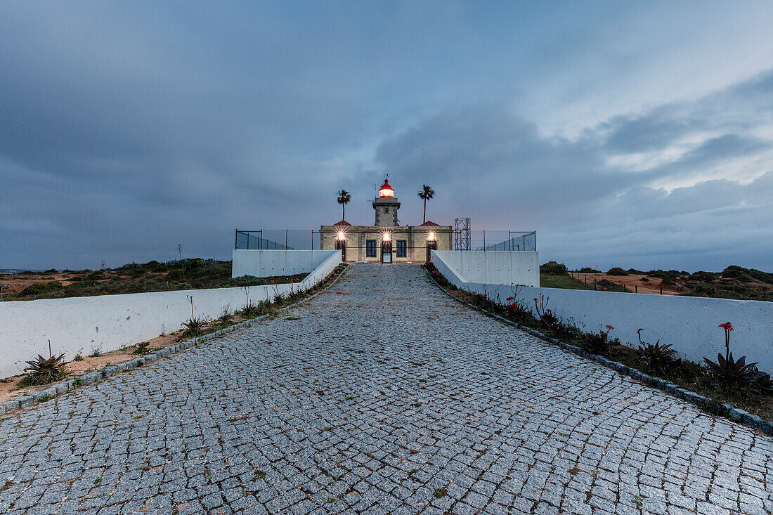 Dusk lights up the the lighthouse surrounded by the Atlantic Ocean Ponta Da Piedade Lagos Algarve Portugal Europe