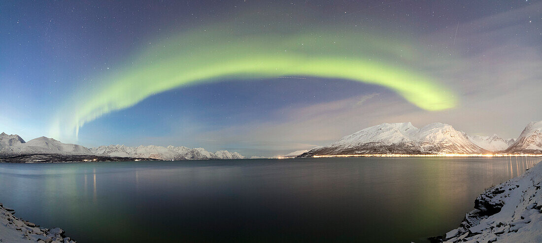 Panorama of frozen sea and snowy peaks illuminated by the Northern Lights Lyngenfjord Lyngen Alps Tromsø Norway Europe