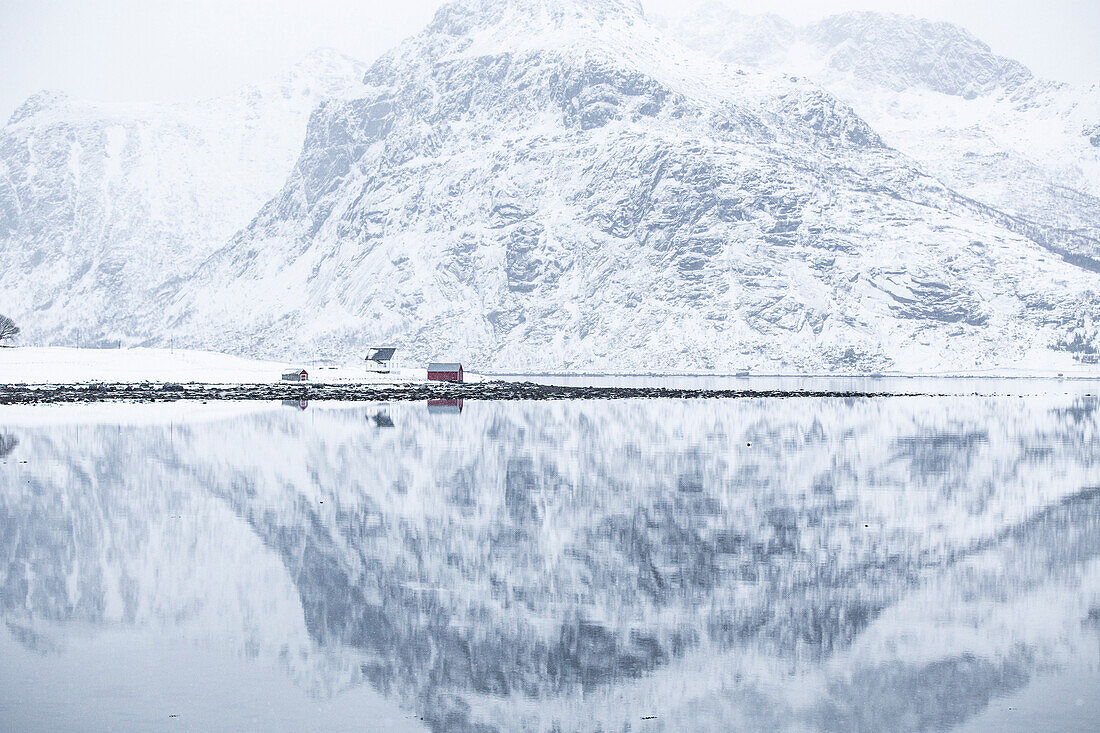 Perfect reflection of mountains and red house, Lofoten Islands, Norway