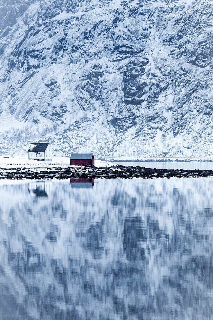 Perfekte Reflexion der Berge und des roten Hauses, der Lofoten, Norwegen