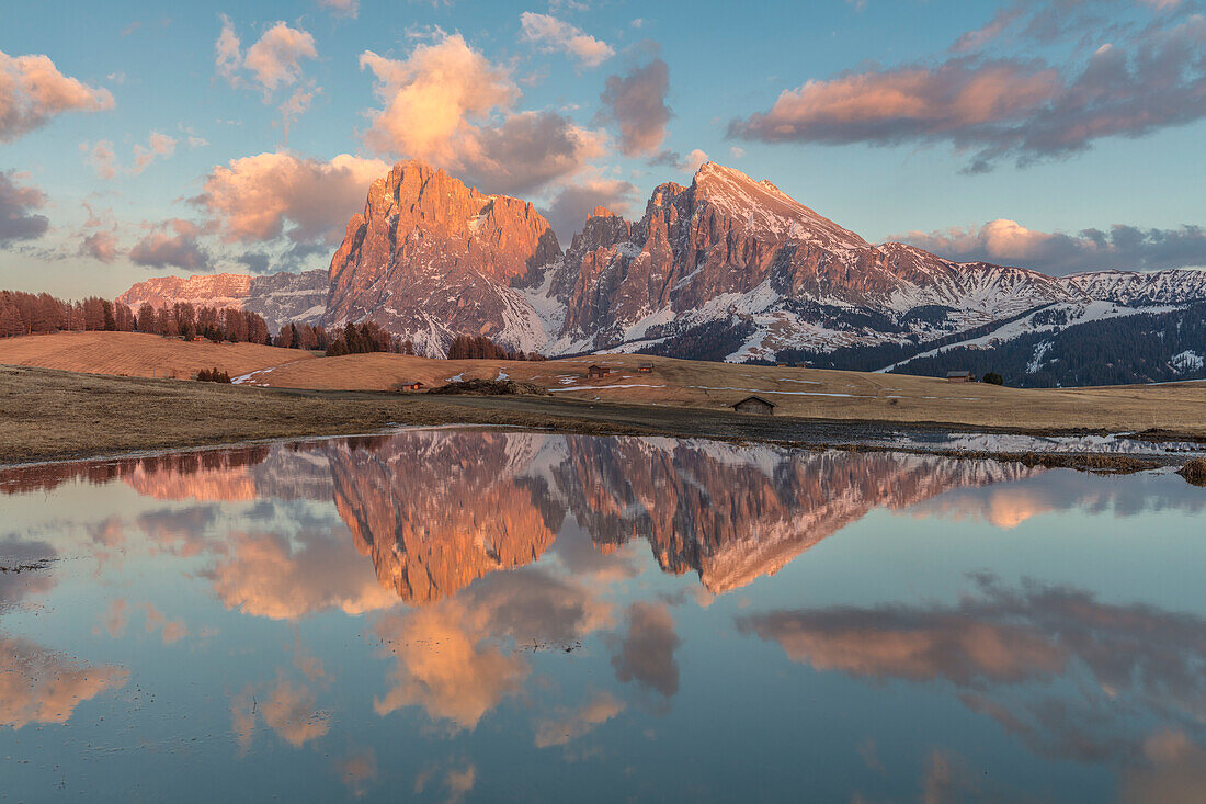 Sonnenuntergangzeit in Seiser Alm, Naturpark Skiliar-Catinaccio, Trentino-Südtirol, Italien, umgeben von weiten Wiesen und idyllischen Hütten