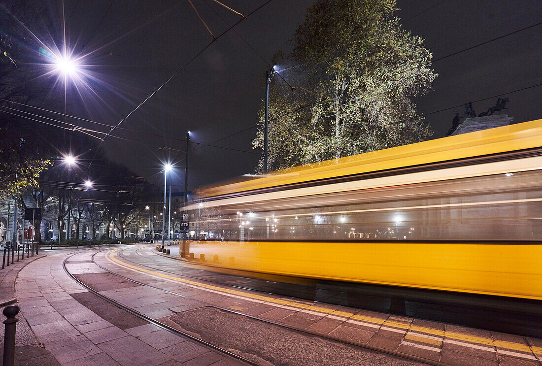 Milan, Lombardy, Italy, The iconic tram runs throught the city bi night