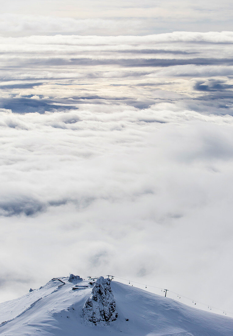 A Chairlift Can Be Seen Running Along A Ridge In Front Of A Large Bank Of Clouds At Cerro Catedral In Argentina