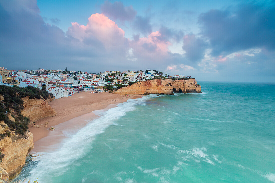View of Carvoeiro village surrounded by sandy beach and turquoise sea at sunset, Lagoa Municipality, Algarve, Portugal, Europe
