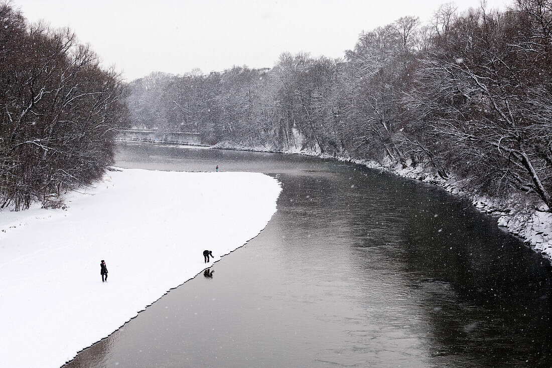 Walking at the river Isar during snow fall, Munich, Germany