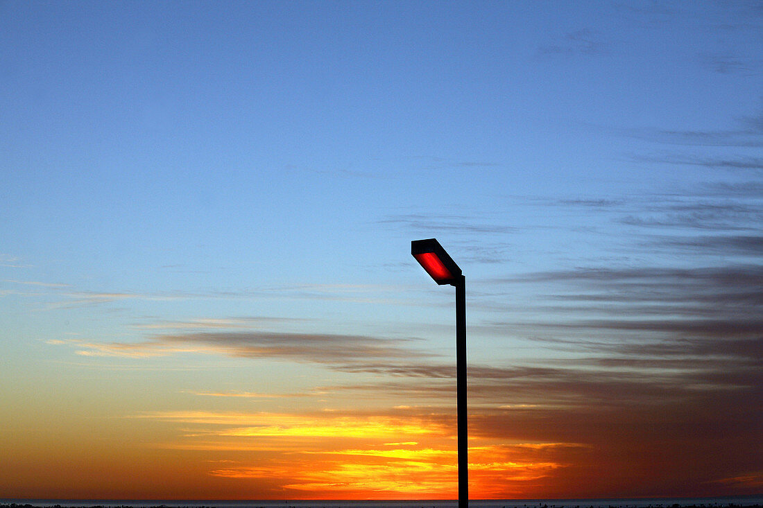 The sun sets over a streetlight in San Diego, California.