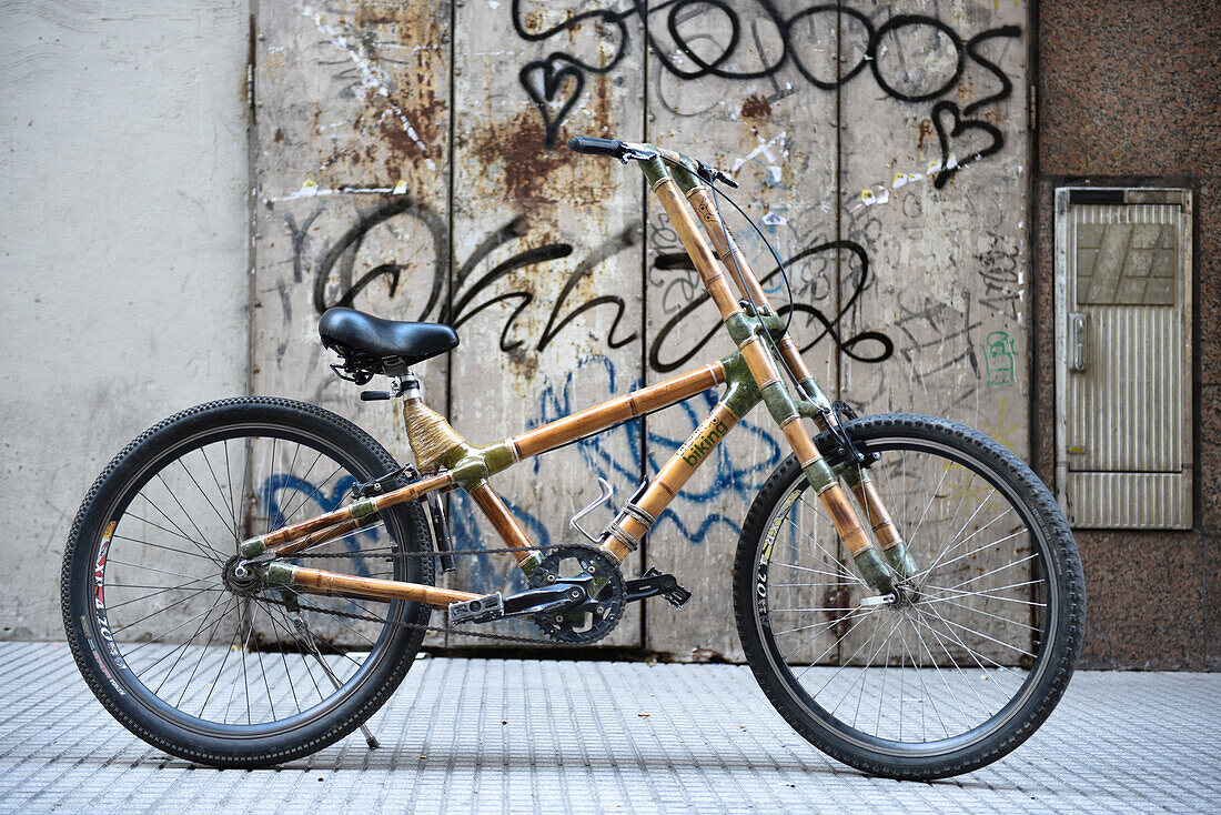 A View Of A Bamboo Bike Standing Against Graffiti Wall In Buenos Aires, Argentina